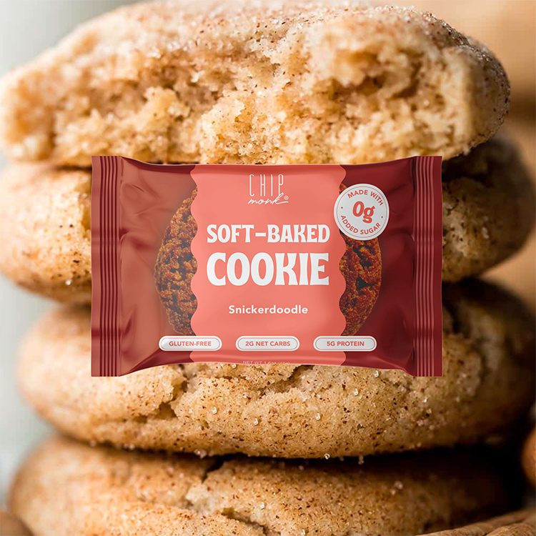 Snickerdoodle cookie with a 'Chip on the Wall' soft-baked cookie package in front of a stack of cookies.