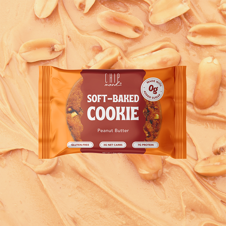 Packaged soft-baked cookie with peanut butter flavor on a background of cookie dough and peanuts.