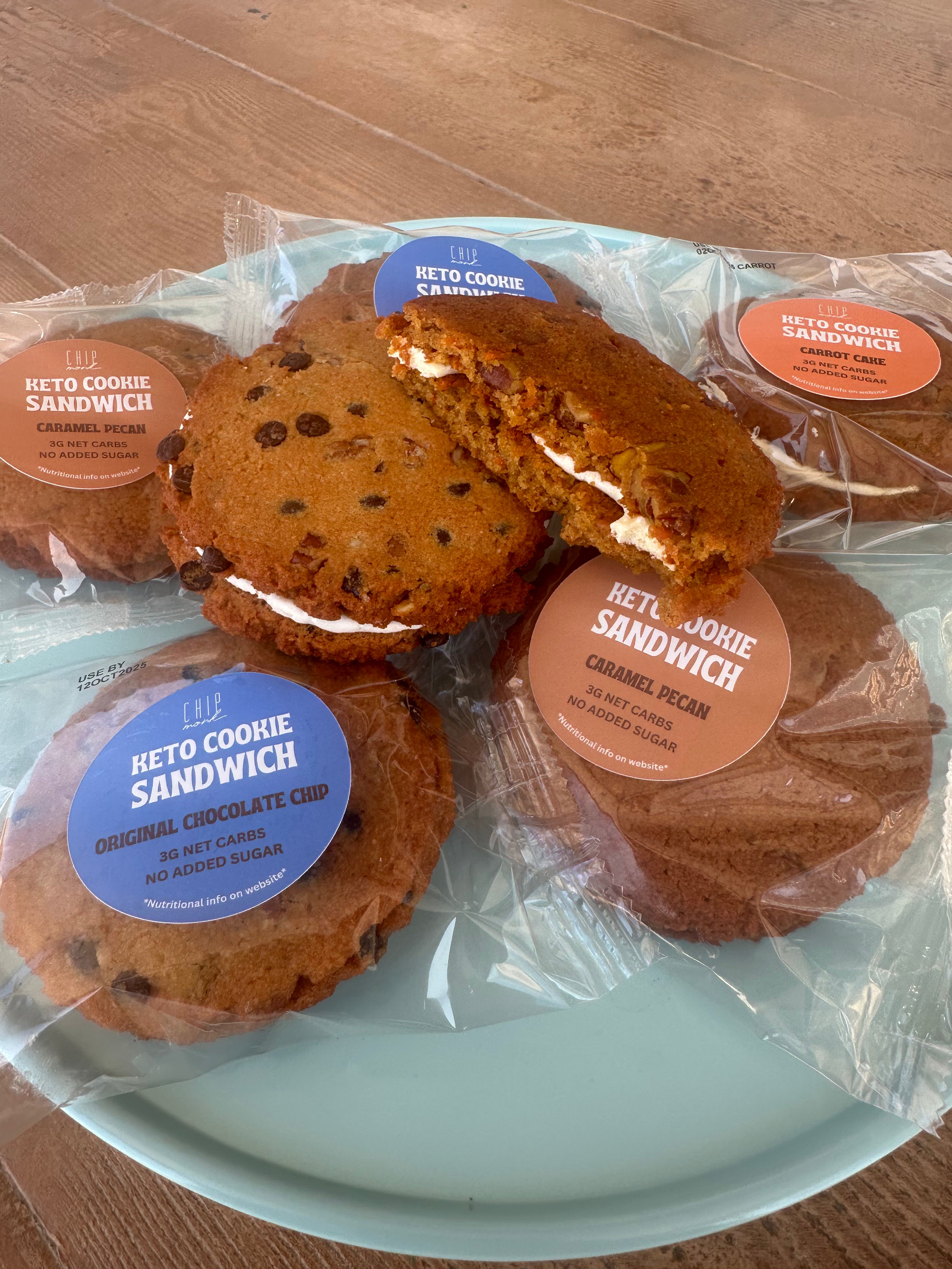 Keto cookie sandwiches in packaging on a light blue plate with wooden background