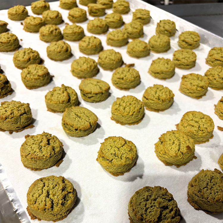 Green cookies on a baking sheet lined with parchment paper
